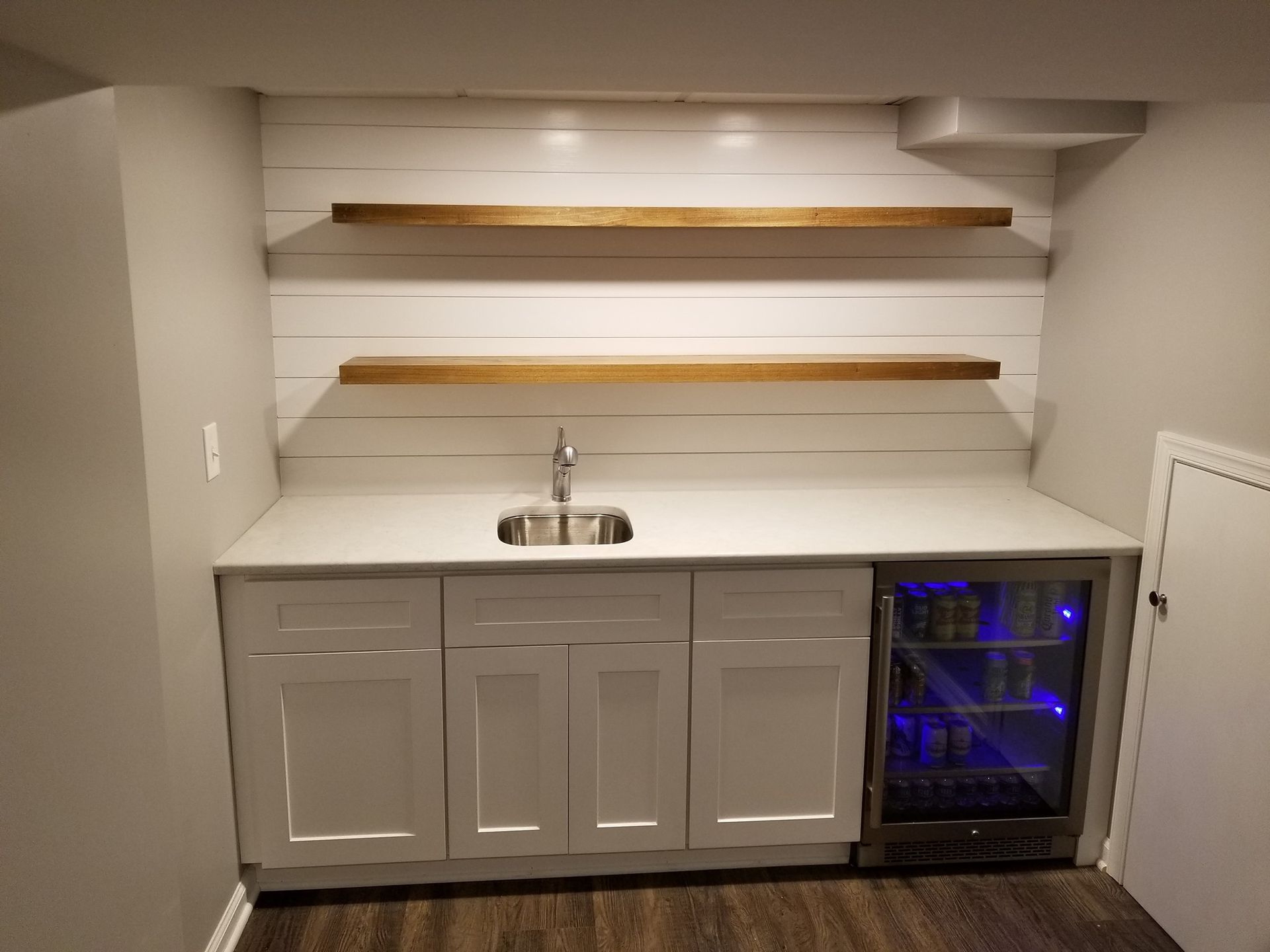 a kitchen with a sink , shelves , and a refrigerator