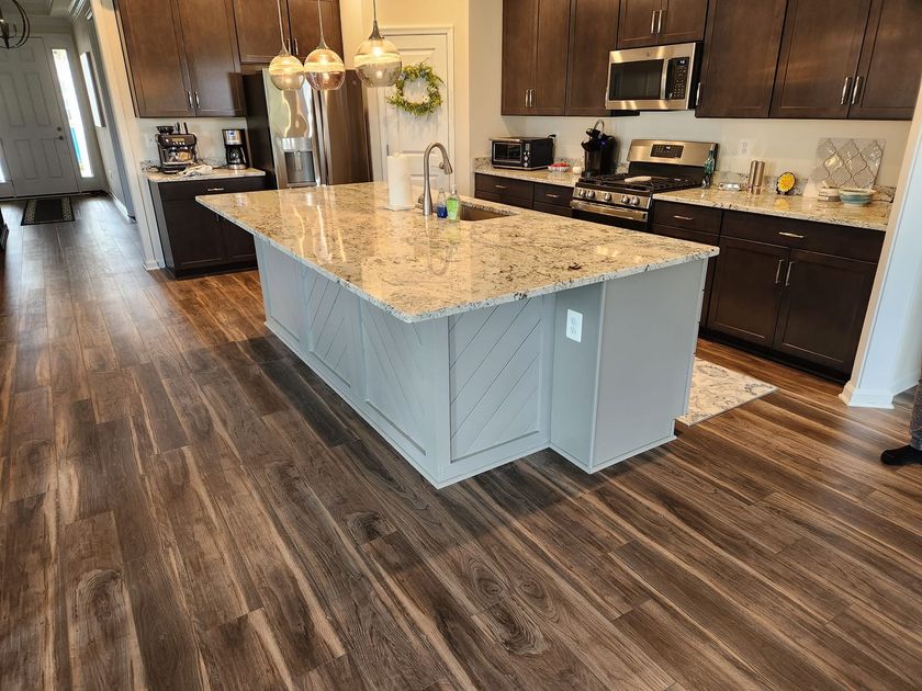 a kitchen with a marble counter top and a refrigerator