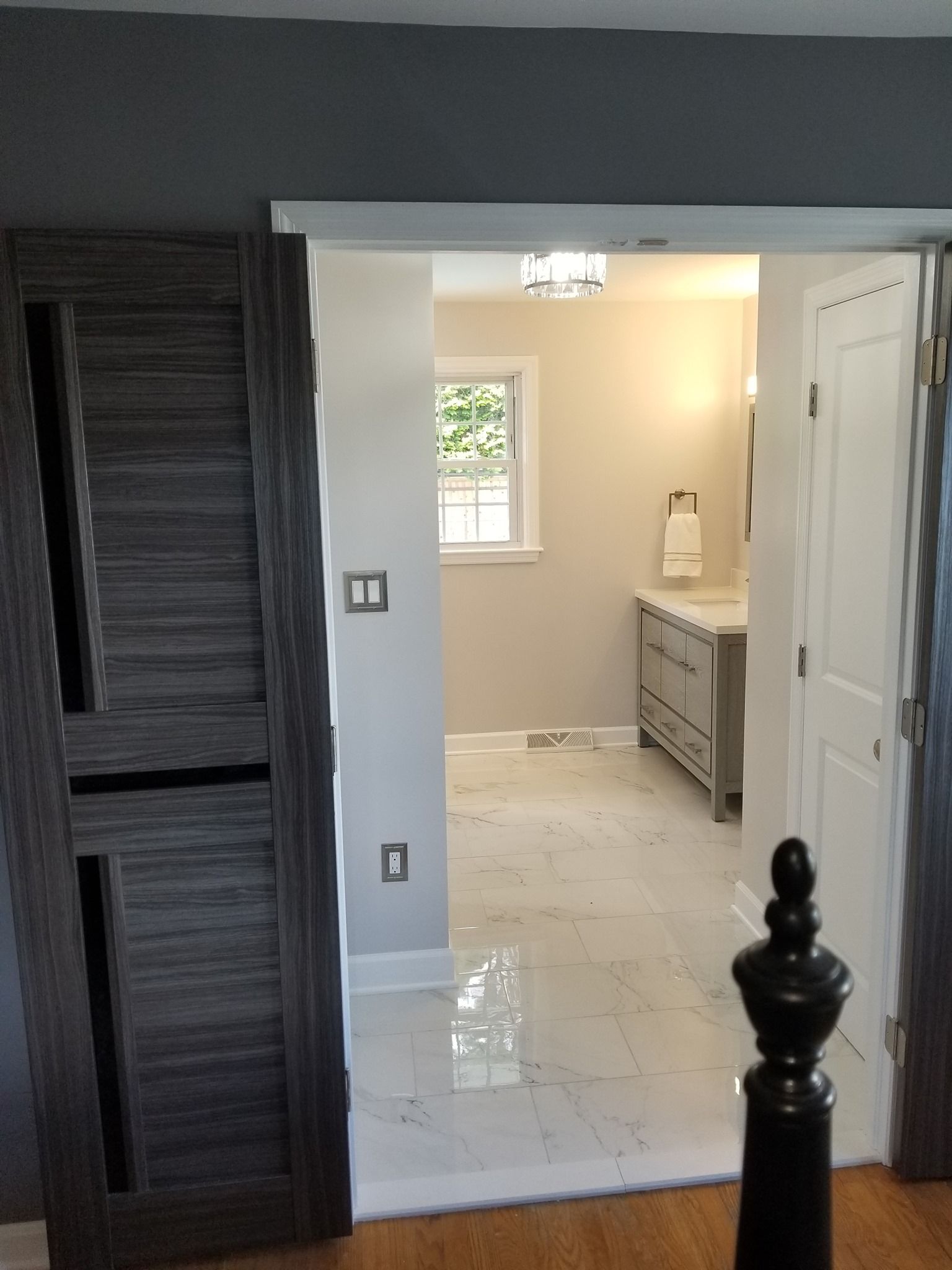 a bathroom with two sinks and a window behind a sliding door