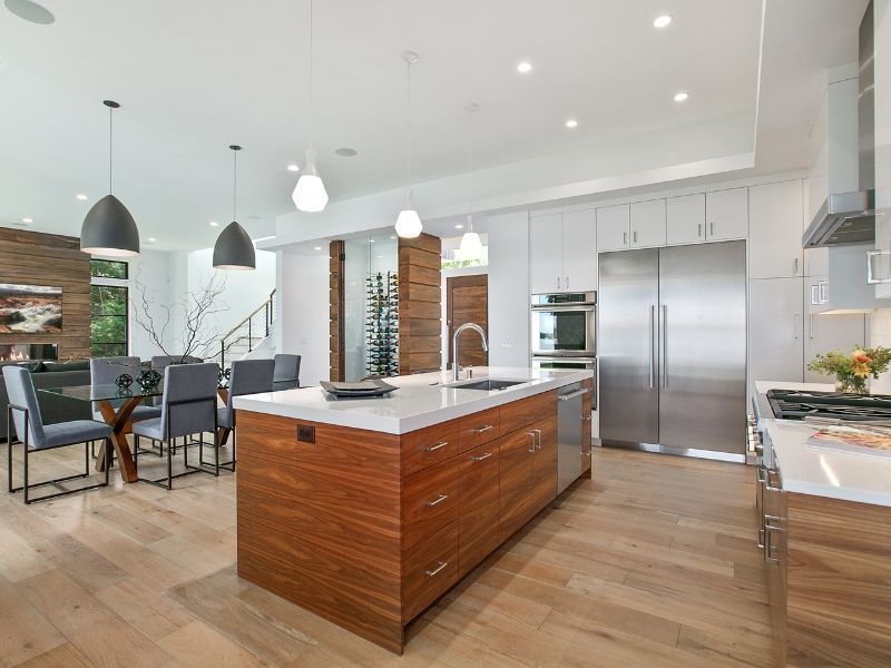 A kitchen with a large island in the middle and stainless steel appliances.