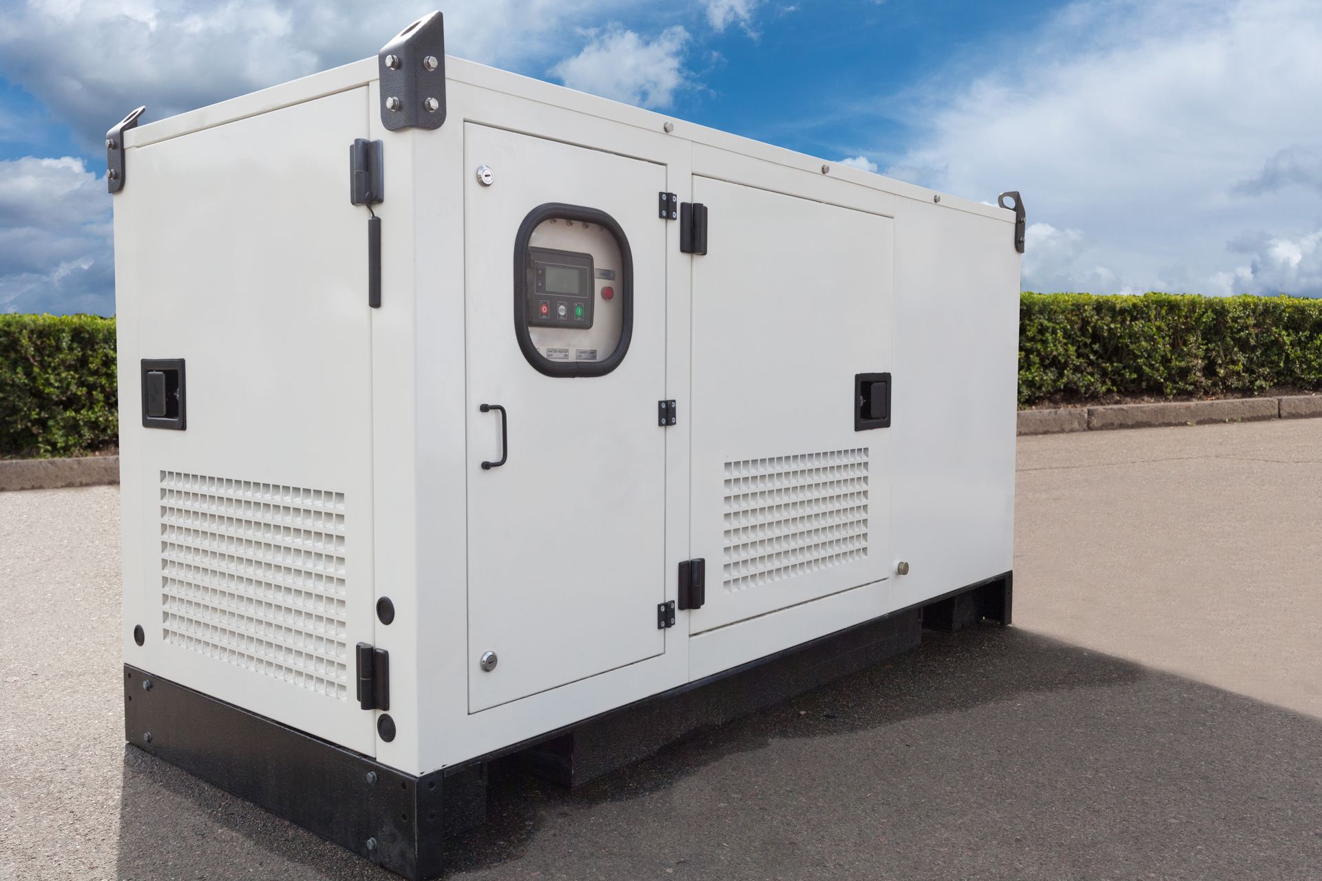 A white generator is parked on the side of the road.