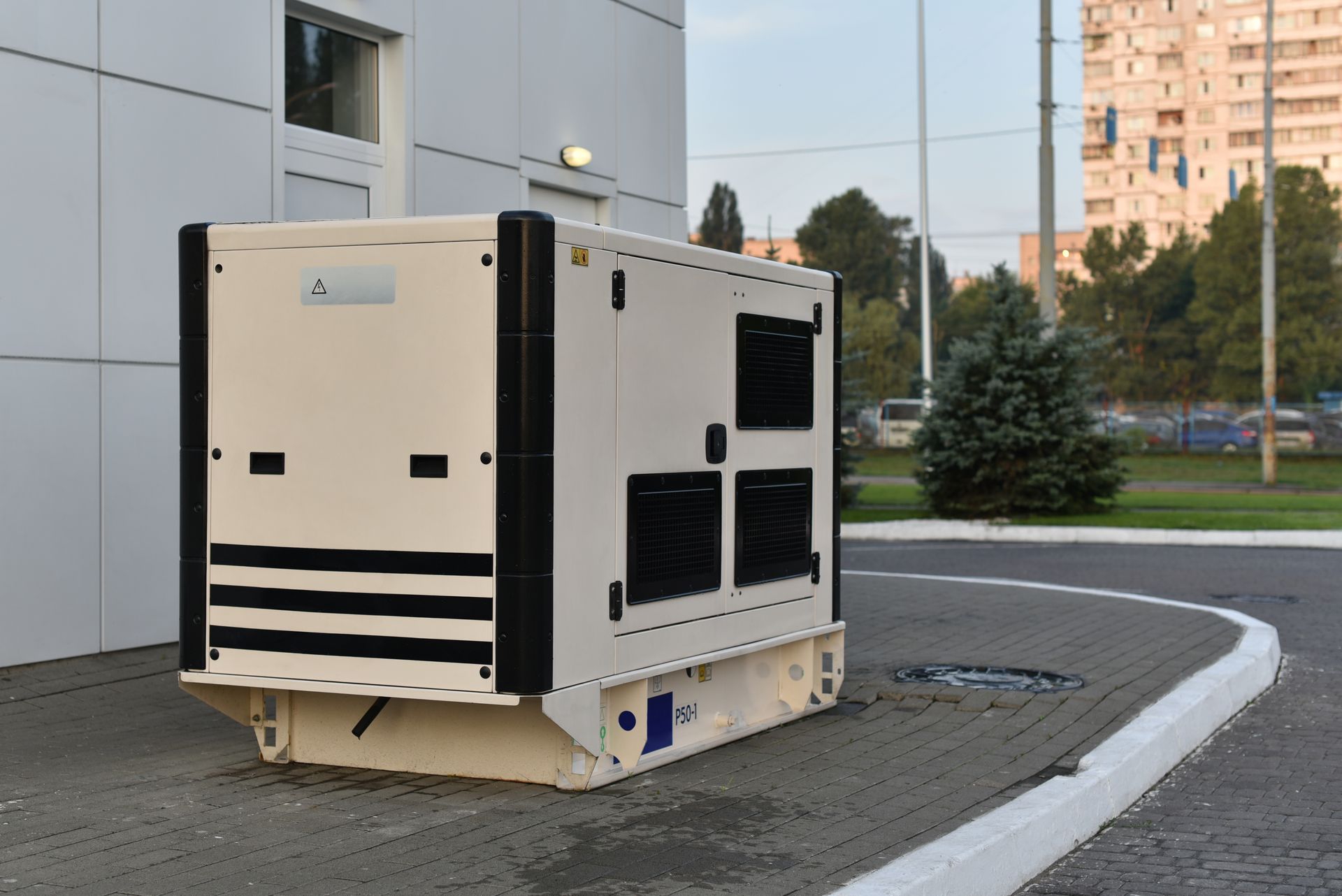 A white generator is parked on the side of the road.