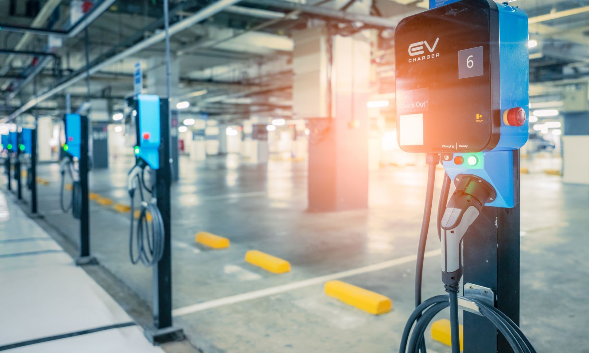 A row of electric vehicle charging stations in a parking garage.