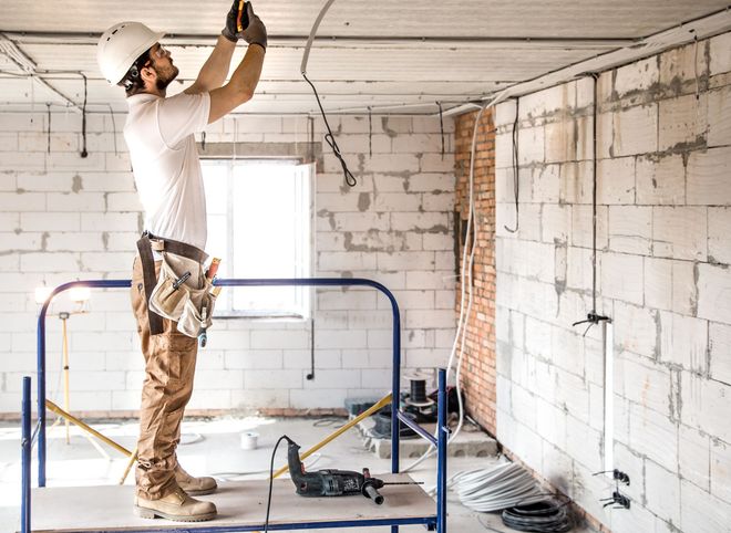 A person is changing a light bulb in a ceiling light.