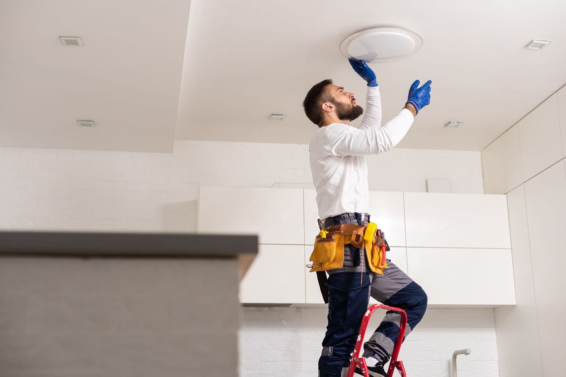 A person is changing a light bulb in a ceiling light.