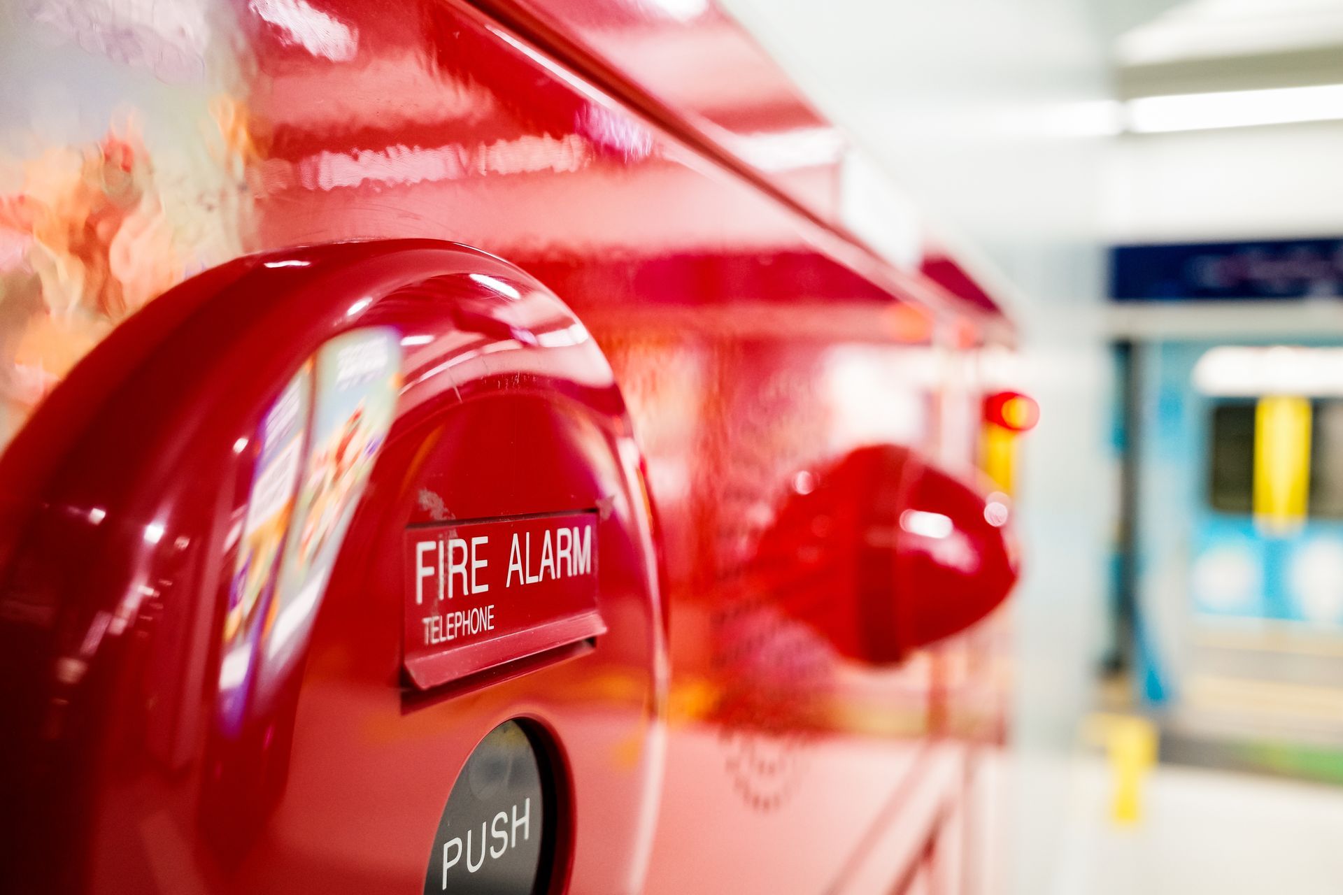 A close up of a red fire alarm in a subway station.
