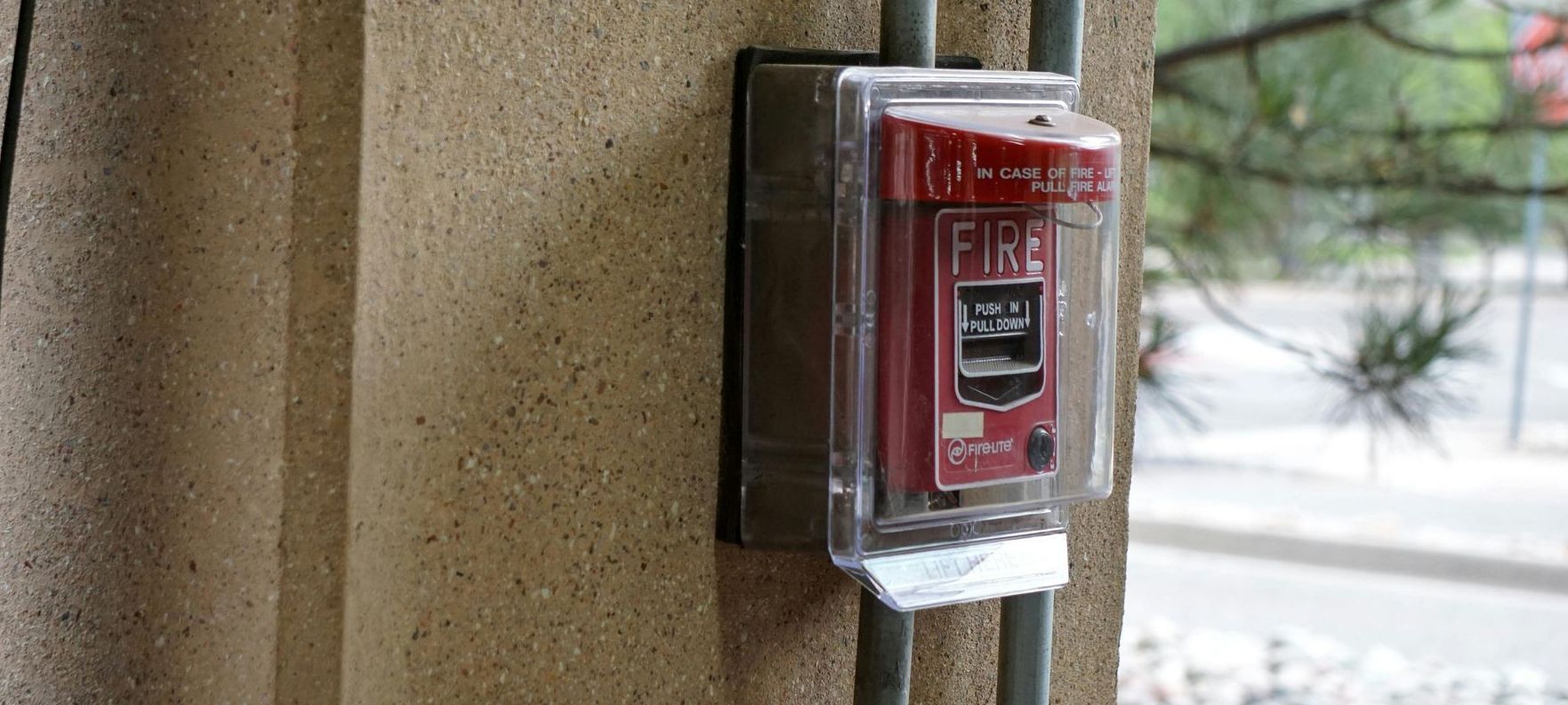 Fire alarm box in a wall of a building.