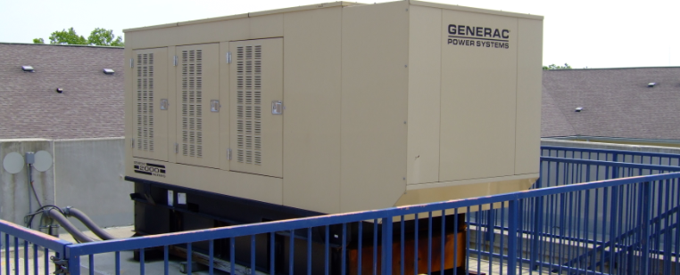 A huge generator on top of a commercial building.