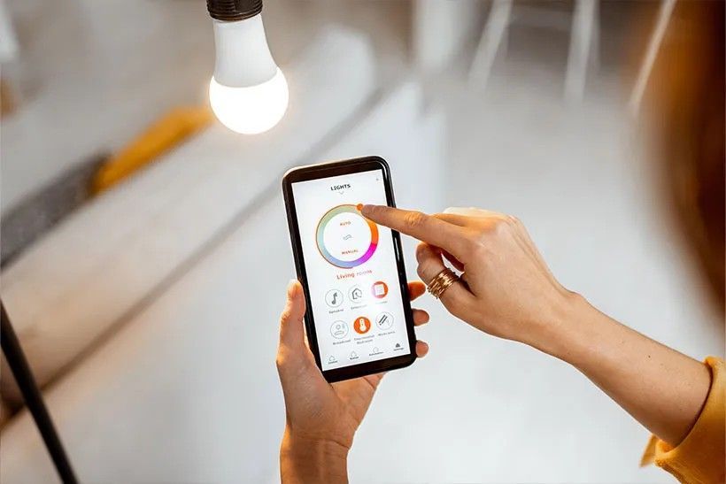 A woman managing her smart lighting system through her phone.