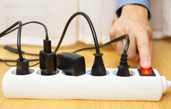 A multi-socket plugged with too many electrical wires.