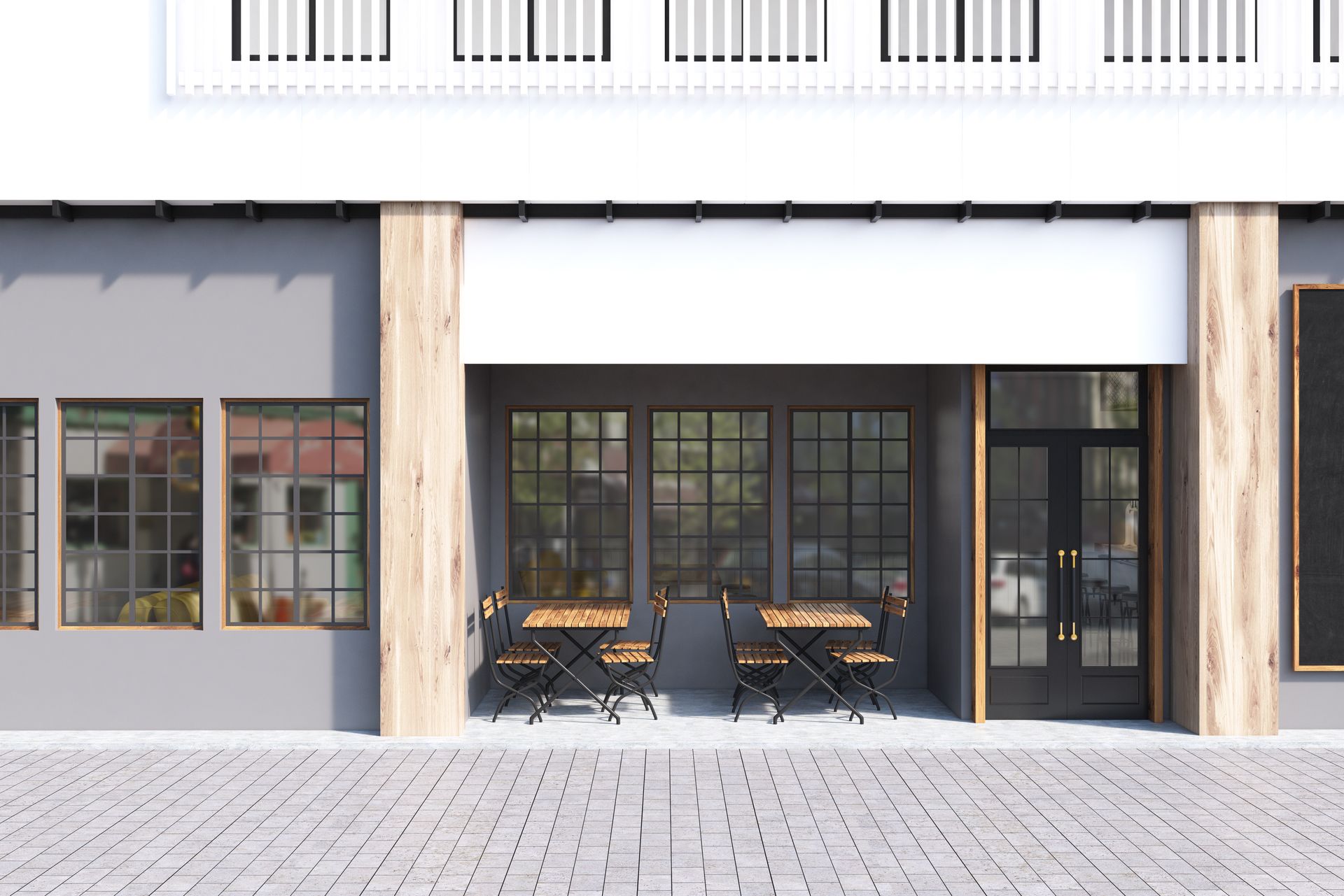 Cafe exterior with tables, windows, and a white awning. Gray building with stone walkway.