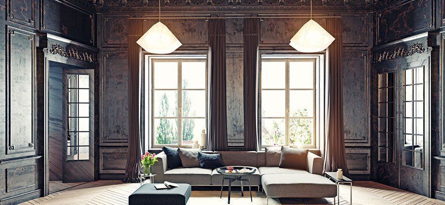 Living room with large windows, sofa, and modern pendant lights. Dark wood paneling and ornate trim.