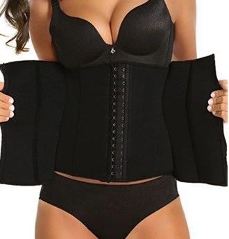 A woman in a black bra and black underwear is wearing a black waist trainer.