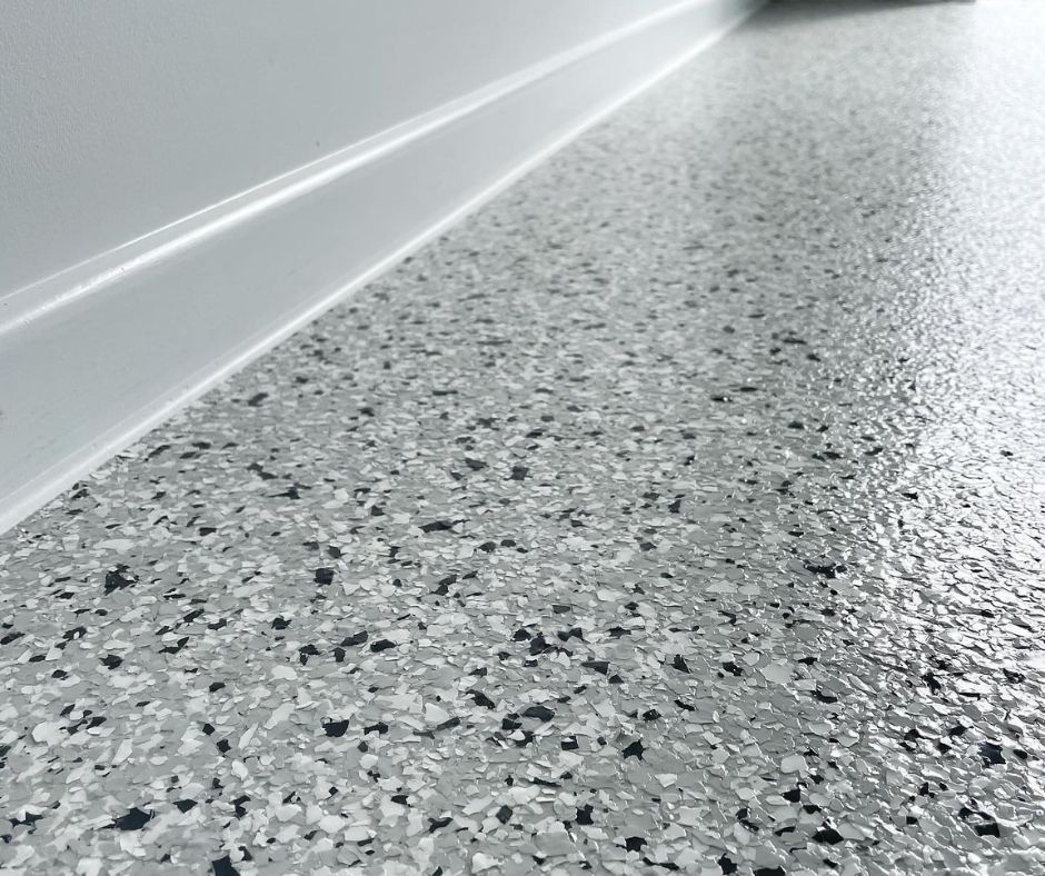 A close-up view of a grey and white speckled epoxy flooring.
