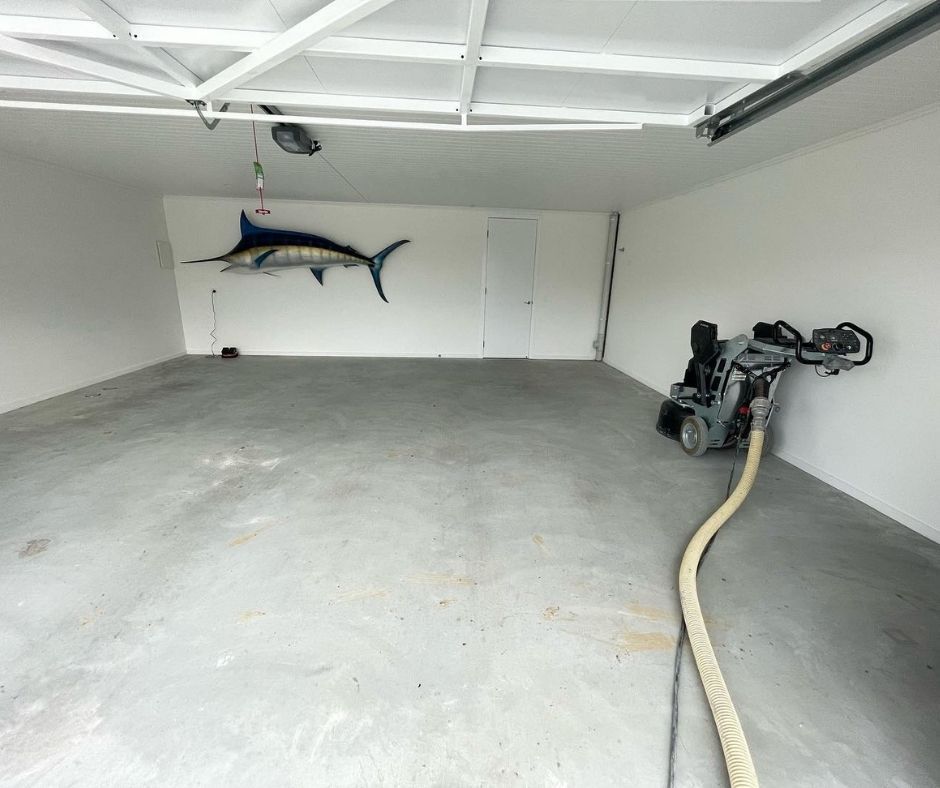 A floor sander in an empty garage for surface preparation.