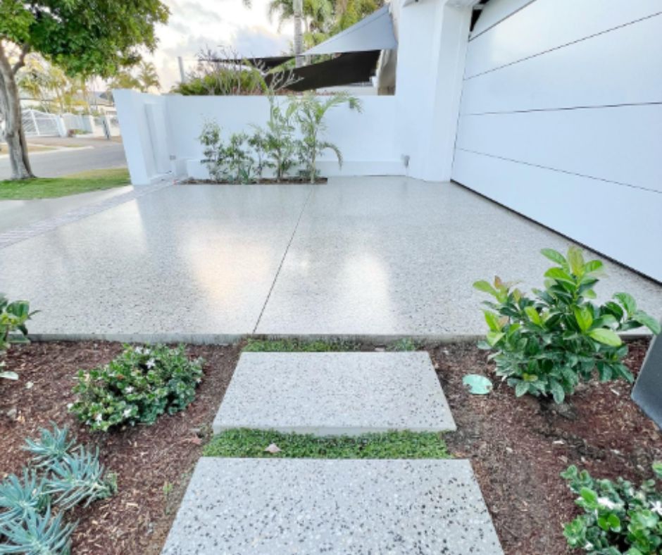 Honed concrete driveway with polished finish and garden edging.