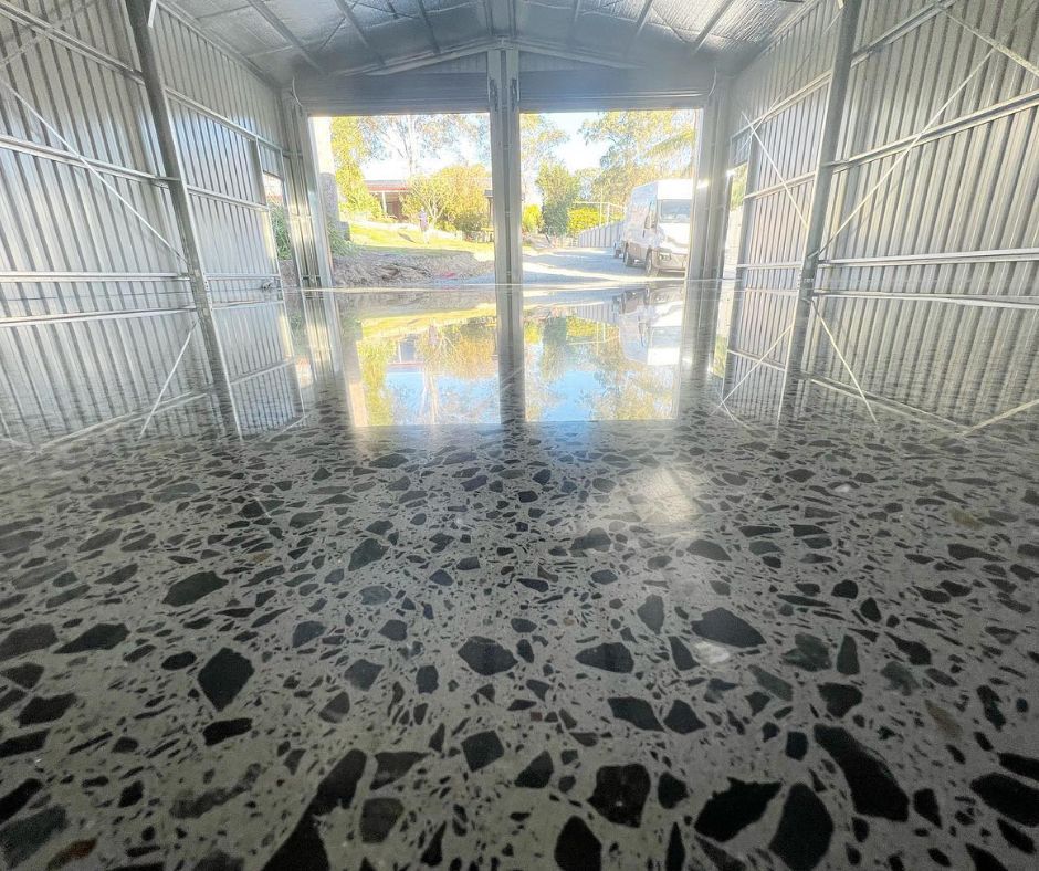 A close-up photo of a speckled polished concrete floor completed by Coulsons Concrete Finishes