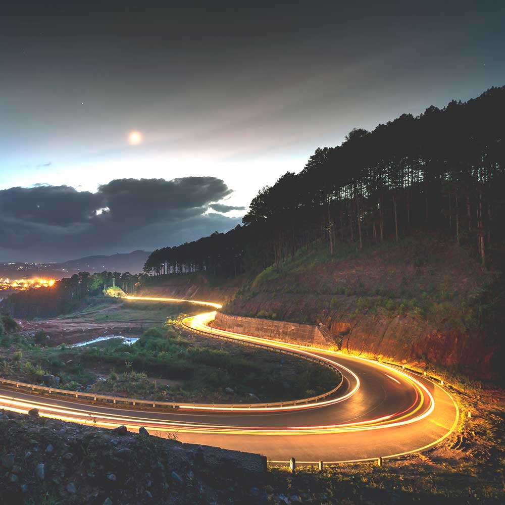 A long exposure photo of a curvy road at night