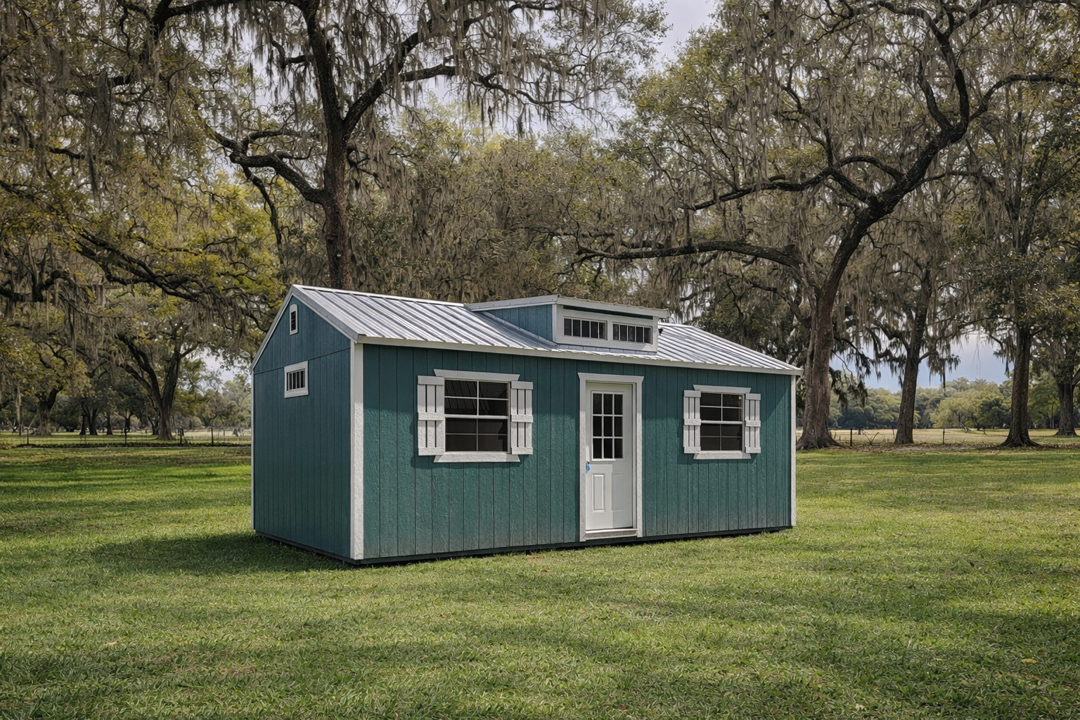 Black shipping container building with rooftop deck and adjacent small dome structure, in a landscaped outdoor setting.