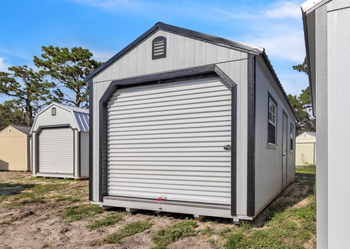 White garage with gray trim and closed, vertical-paneled door; concrete driveway.