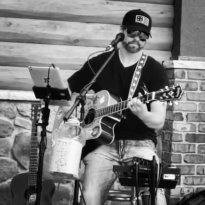 A group of people are standing on a stage in front of a bud light sign.