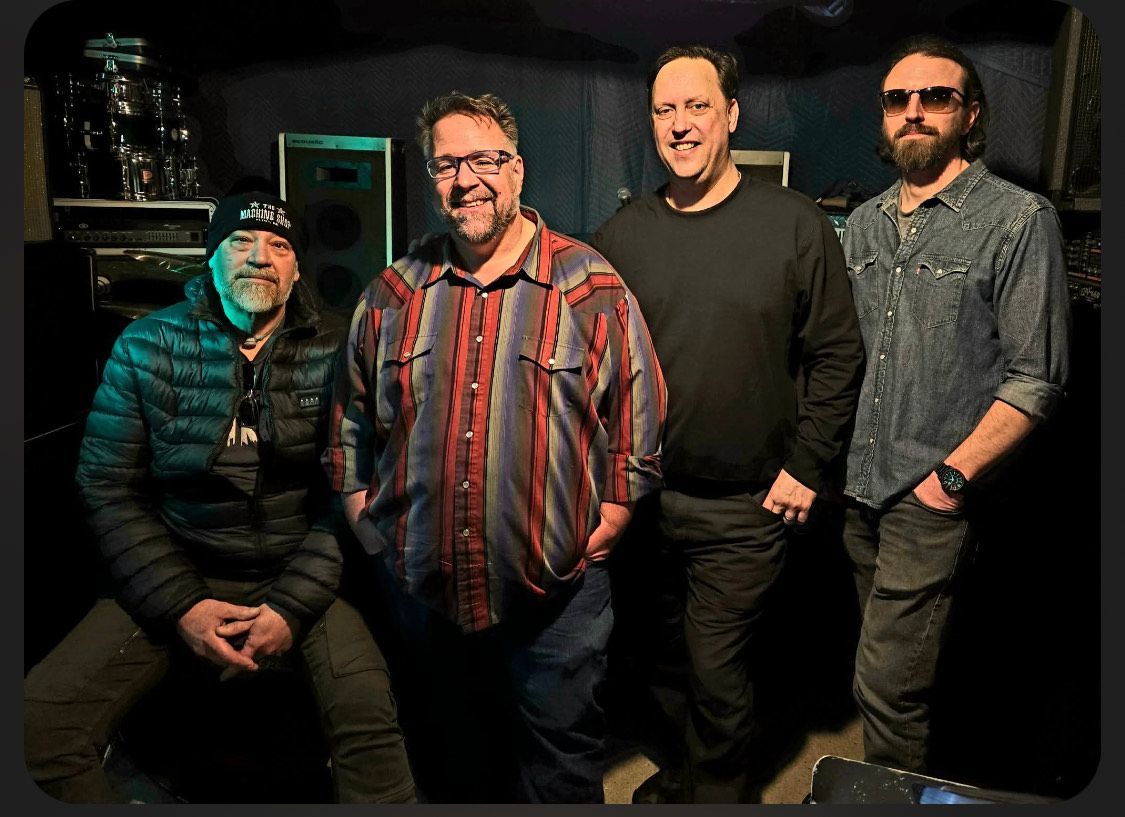A group of people are standing on a stage in front of a bud light sign.