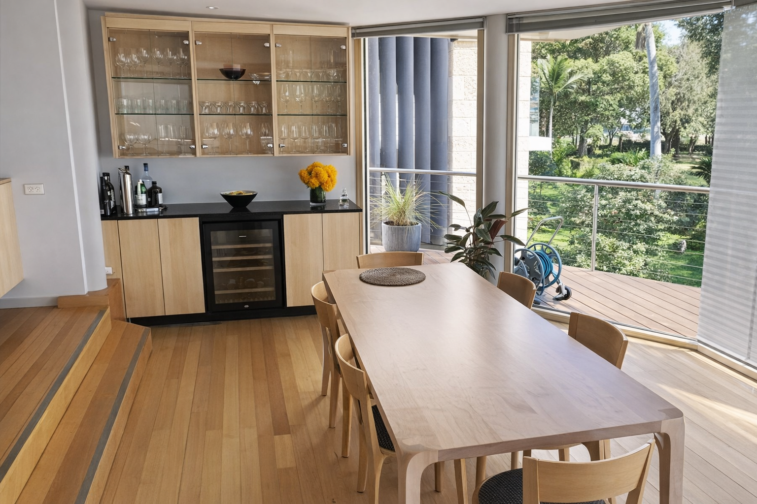 Dining Room With Wooden Table, Chairs, Bar Cabinet, and Window Overlooking Trees — Norrland in Warners Bay, NSW
