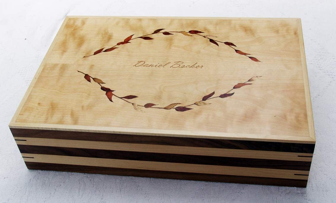 Wooden box with a leaf design around the text 