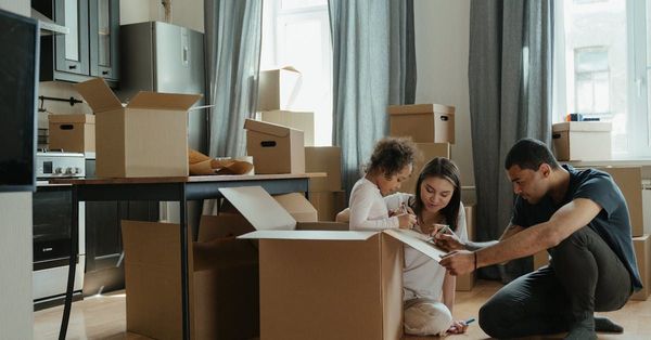 A family is moving into a new home and playing with cardboard boxes.