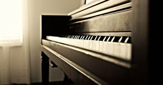 A black and white photo of a piano in a room.