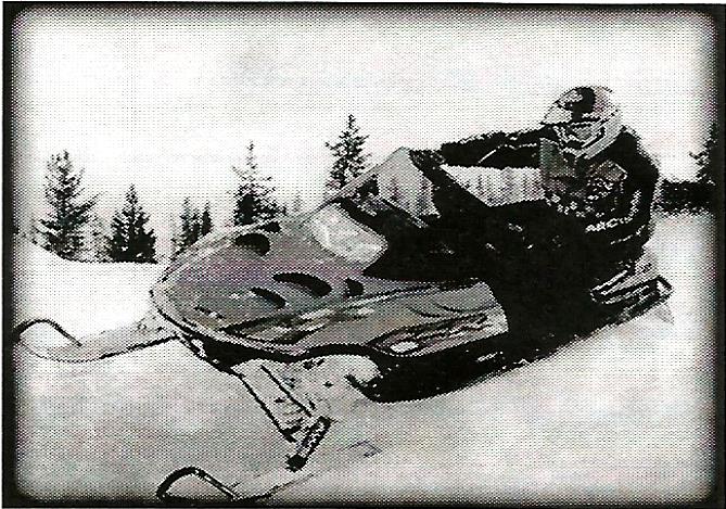 a black and white photo of a person on a snowmobile