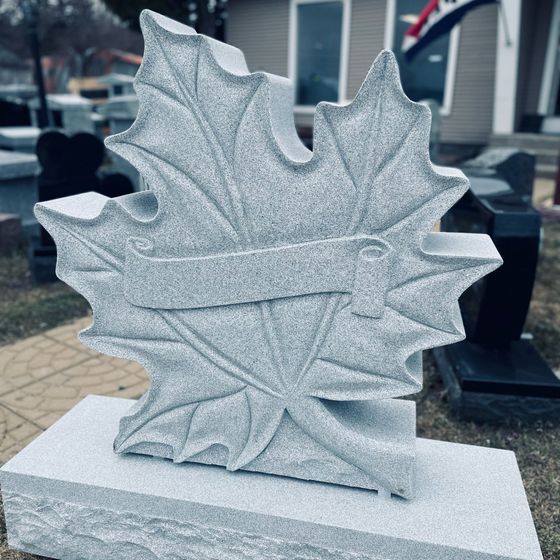 a gravestone in the shape of a maple leaf