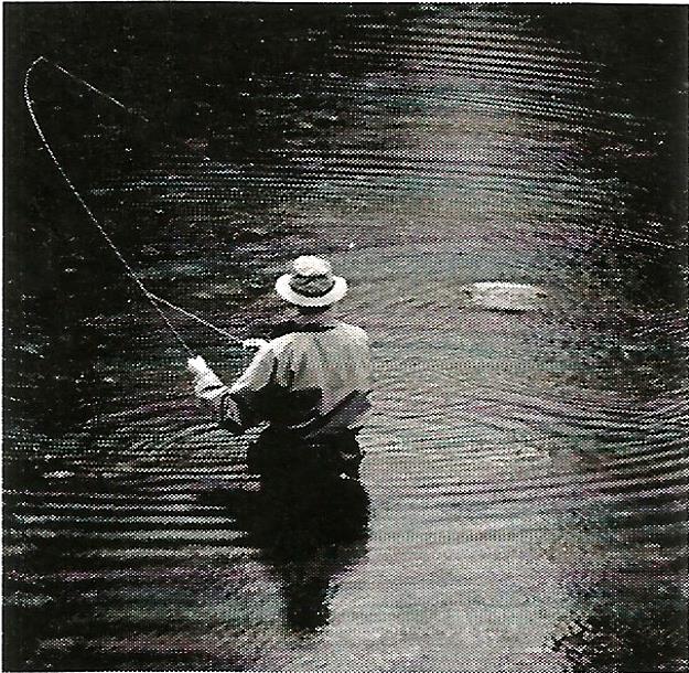 a man in a hat is fishing in a river