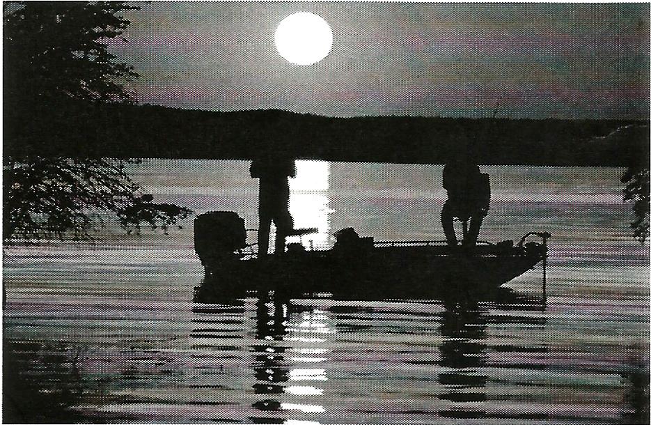 two people in a boat on a lake at night