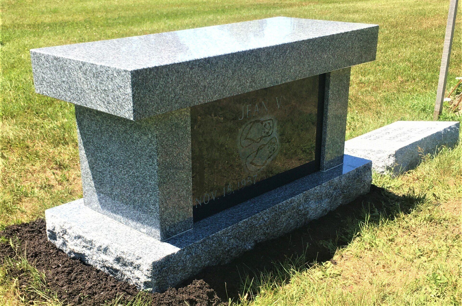 Gray granite cremation bench installed by Champlain Monuments.
