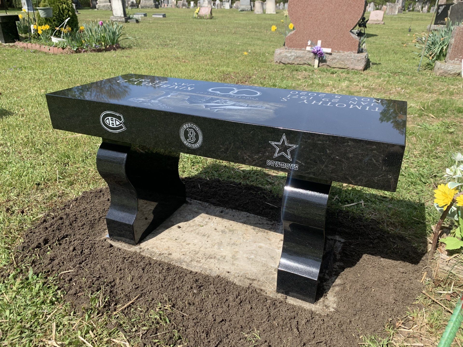 a black bench with etchings installed by Champlain Monuments