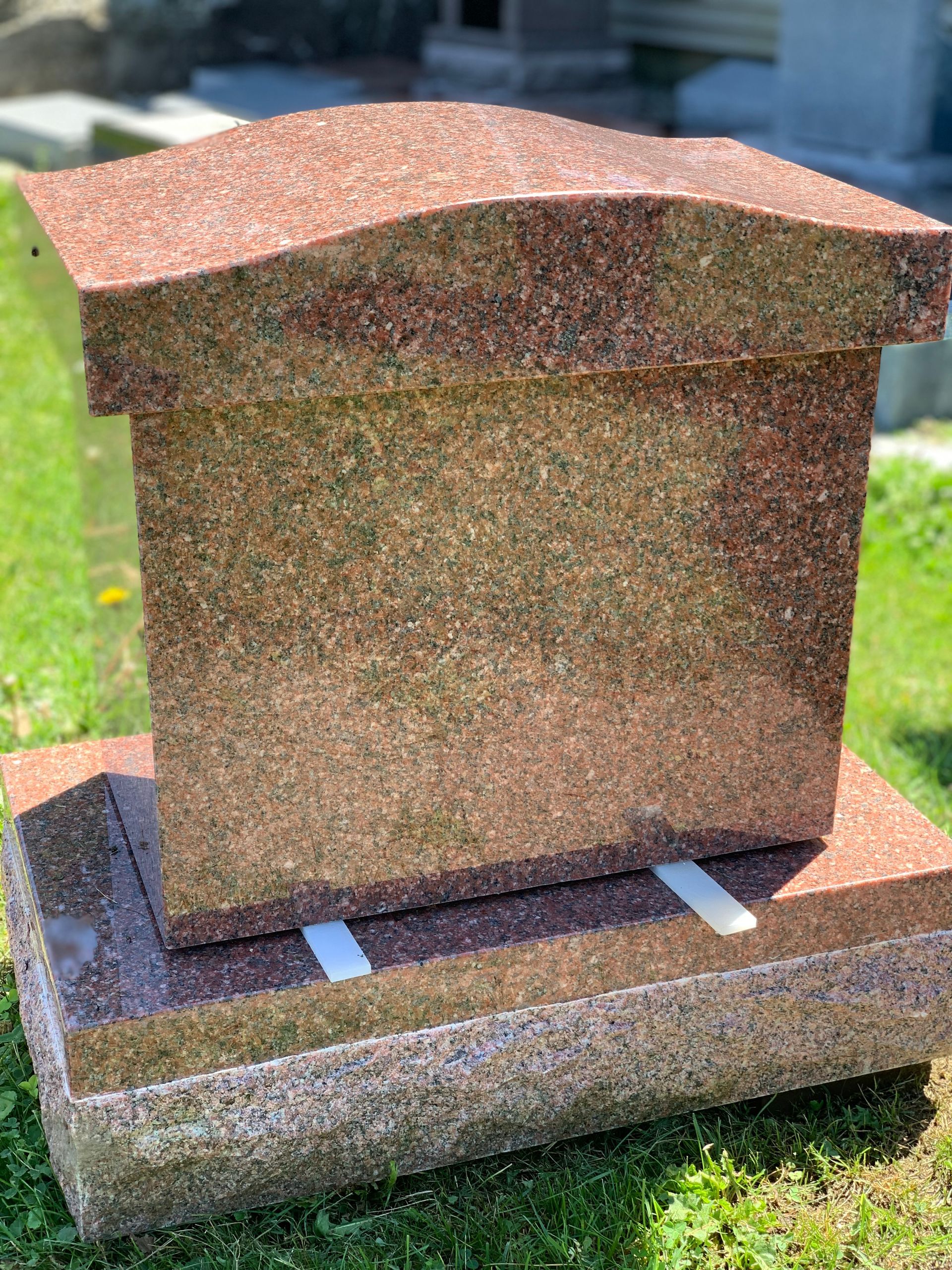 a red single person cremation monument at Champlain Monuments