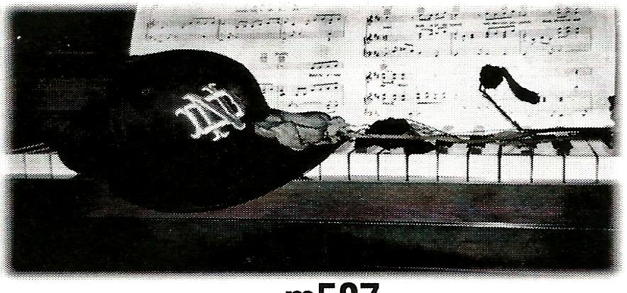 a black and white photo of a hat on a piano keyboard