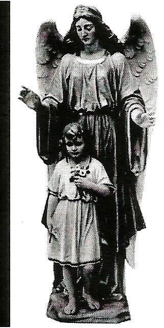 a statue of an angel standing next to a little girl