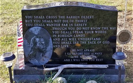 a gravestone with a picture of jesus on it .