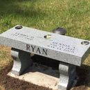 a grave with a bench in front of it that says ryan
