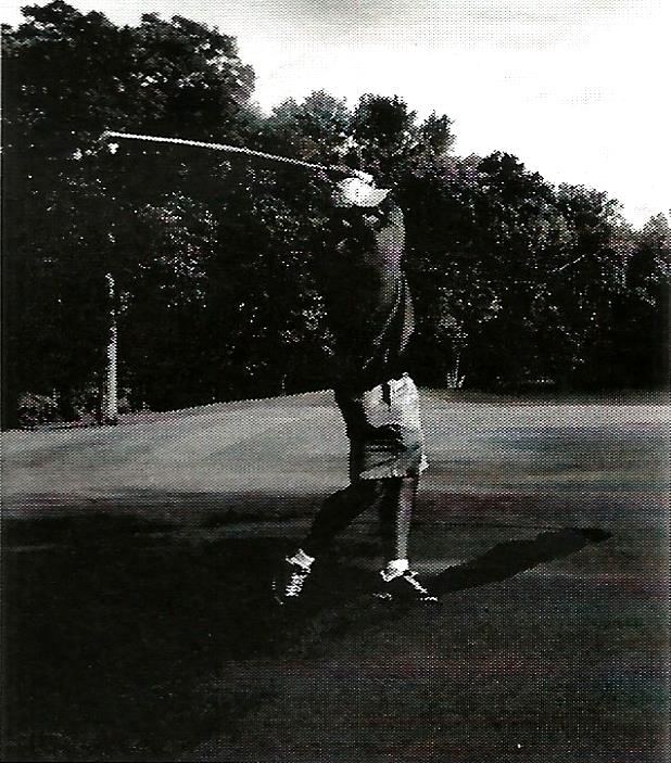 a black and white photo of a man swinging a golf club