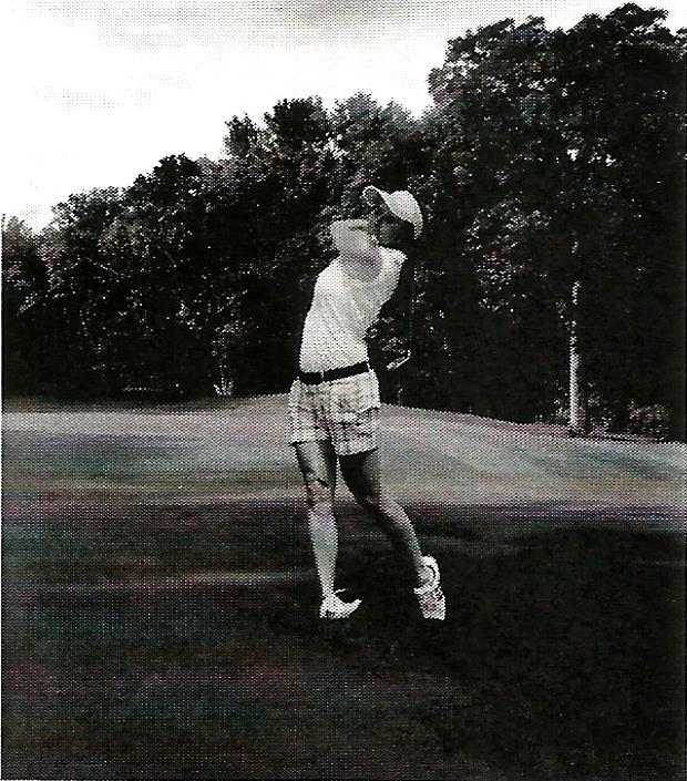 a black and white photo of a person swinging a golf club