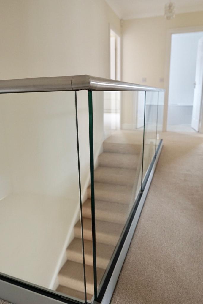 New glass balustrade with a bottom glazing channel and a stainless steel slotted handrail example 7