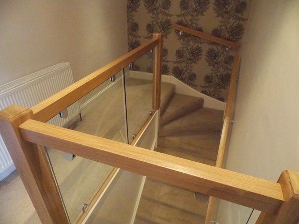 Oak and glass balustrade and oak handrail mounted on chrome brackets example 5