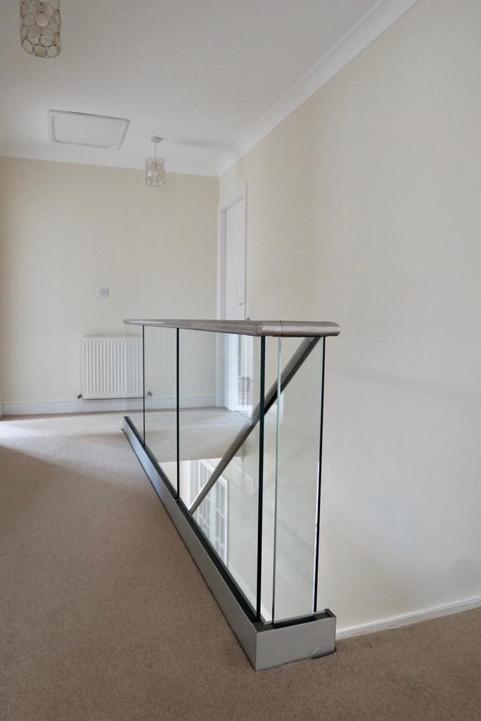 New glass balustrade with a bottom glazing channel and a stainless steel slotted handrail example 10