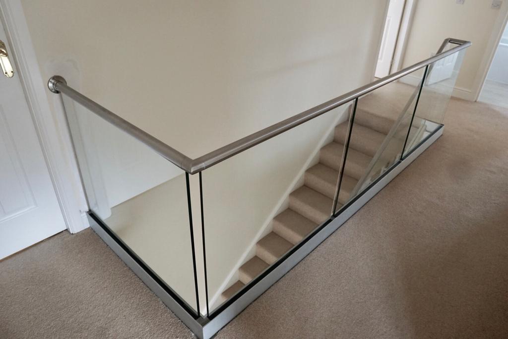 New glass balustrade with a bottom glazing channel and a stainless steel slotted handrail example 6