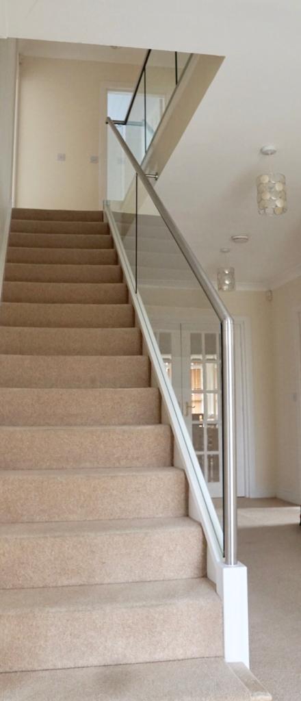 New glass balustrade with a bottom glazing channel and a stainless steel slotted handrail example 5