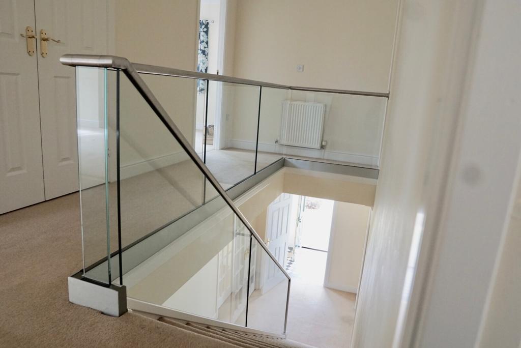 New glass balustrade with a bottom glazing channel and a stainless steel slotted handrail example 11