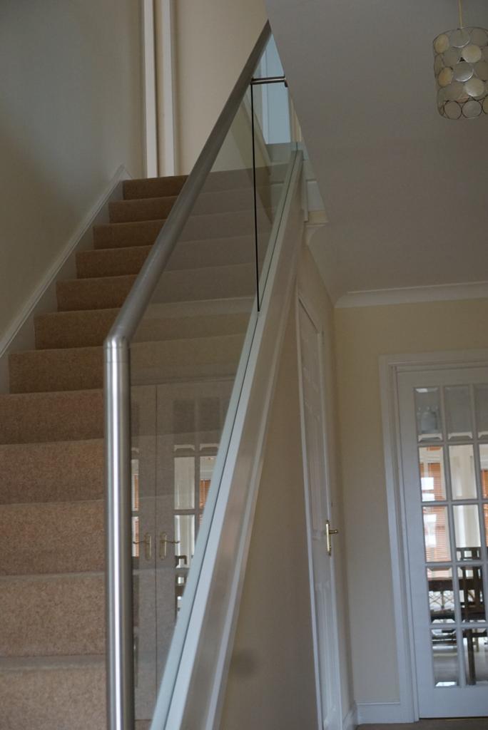 New glass balustrade with a bottom glazing channel and a stainless steel slotted handrail example 8